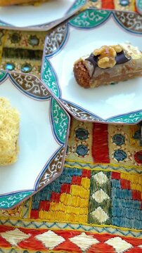 Vertical video of Exotic pastry selection with honey, walnuts and sesame on traditional embroidered fabric