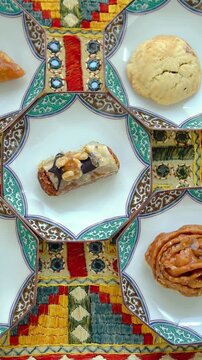 Portrait video of Traditional Moroccan desserts with honey and nuts on a colorful ethnic tablecloth