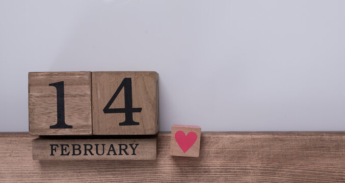 Rustic wooden blocks display February 14, symbolizing love and Valentine's Day.