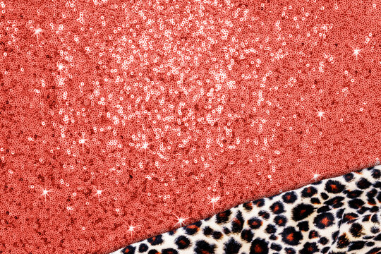 Bright red sequin fabric and leopard print fabric laid out in a flat arrangement on a surface