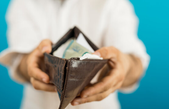 Close-up shot of a person holding an open wallet with money, conveying concepts of finance and wealt