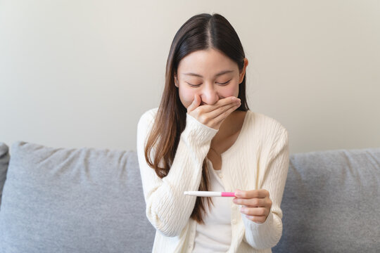Close-up young woman checking on the pregnancy test and the result is positive.