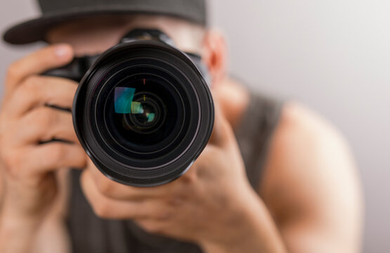 Close up photo of person looking through a camera lens focusing to take a picture