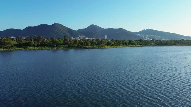 Serene lake landscape with distant mountains and lush green shoreline