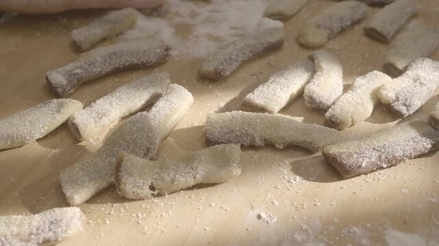 Woman hands sprinkle sugar over cookies before baking. The finishing touch adds texture and sweetness, enhancing the homemade baking experience.