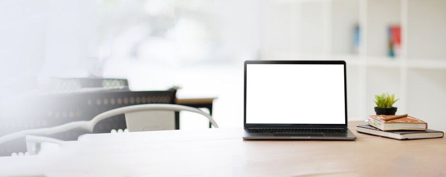 Modern Minimalist Workspace with Blank Screen Laptop Mockup on Wooden Desk in Bright Blurred Office Interior