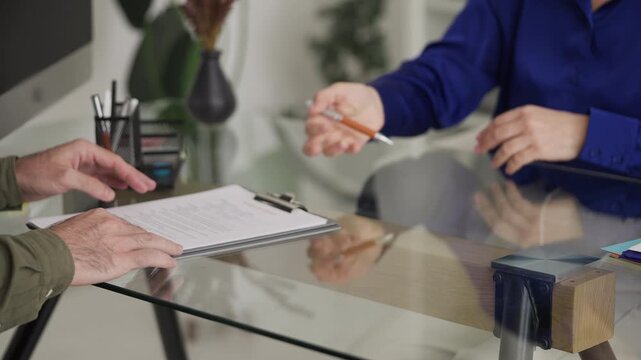 Man signing divorce settlement agreement during consultation with woman lawyer