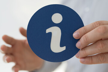 Fototapeta na wymiar Man holding an information icon for assistance guidance and help
