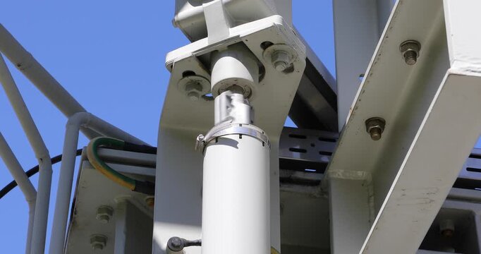 Close-up of a transformer bushing insulator mounted on high voltage electrical equipment. The image shows a structural connection point used for conducting electricity through grounded barriers. 