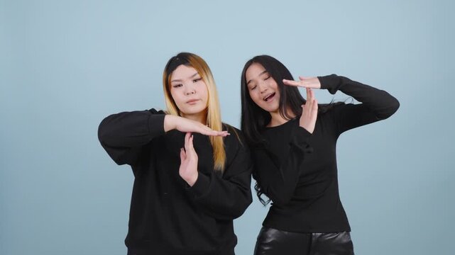 Two young women showing time out gesture with hands in studio