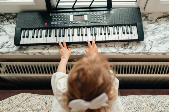 Child Playing Keyboard On Windowsill, Aspiring Young Pianist Practicing Morning Routine With Small Hands