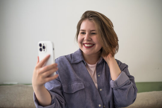Plus size woman taking selfie with smartphone, video call, social media content, online communication, remote friendship, mobile lifestyle, body positivity, confidence