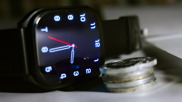 Digital smartwatch with Indonesian rupiah coins representing time and financial management