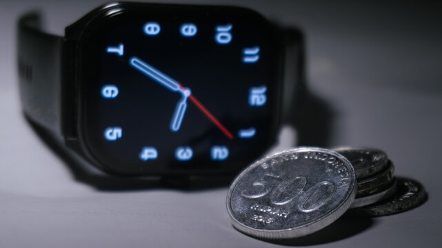 Digital smartwatch with Indonesian rupiah coins representing time and financial management