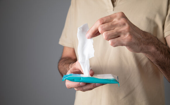 Man cleaning his hand with wet wipe.