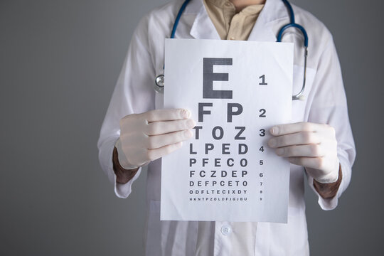 Caucasian doctor showing eye examination test.