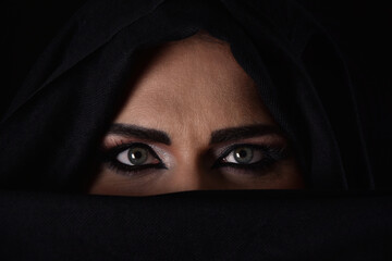 Naklejka premium Closeup of a woman in black veil with expressive green eyed gaze