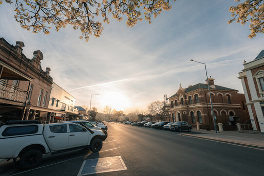 A picturesque street lined with heritage buildings and parked vehicles