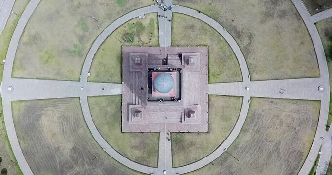 Aerial top down view of Mitad del Mundo monument on equator in Ecuador smooth slow rising drone shot geometric symmetry landmark 4K