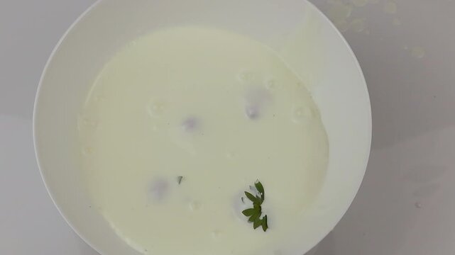 Creamy Sauce Being Poured Into a White Bowl with Fresh strawbery and Soft Ingredients