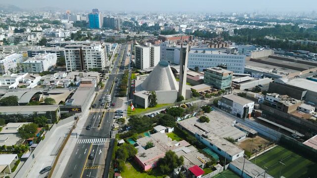 4K aerial perspective of the iconic Santuario del Sagrado Coraz&oacute;n de Jes&uacute;s church, urban landscape of Lima under bright sunlight.