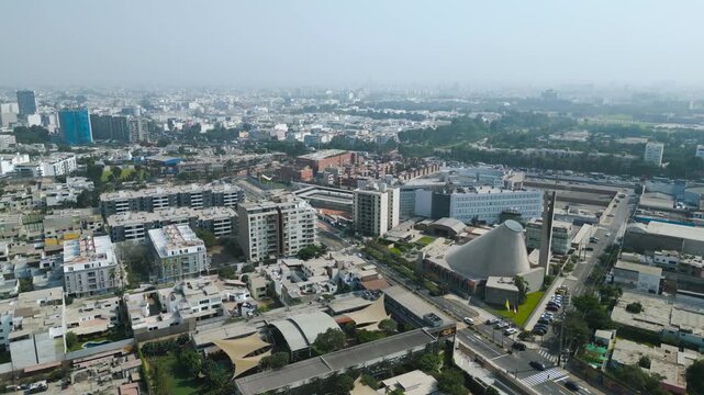 Majestic 4k aerial view of the Sagrado Coraz&oacute;n de Jes&uacute;s sanctuary in Surco, revealing the vast green areas and urban sprawl of Lima on a misty autumn afternoon.