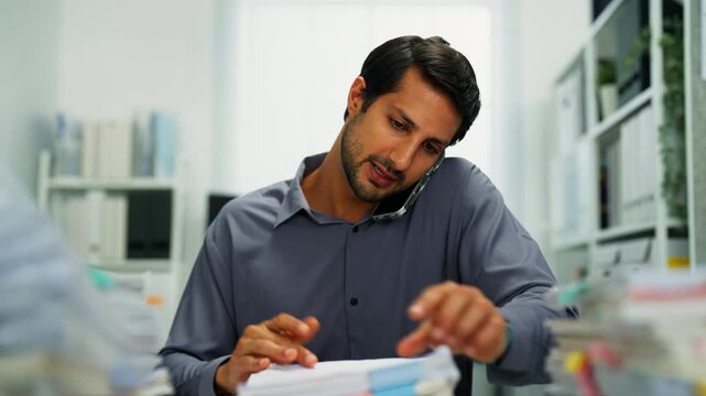 Hispanic worker tired, stressed from paperwork stacks and deadlines, showing eye strain and fatigue.