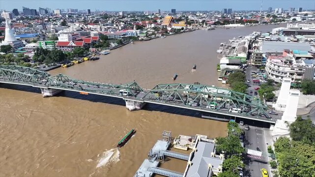 Memorial Bridge or Phra Phuttha Yodfa Bridge crossing river with steel structure and moving vehicles.