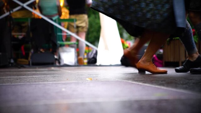 Bayerisches Tanzpaar in Dirndl und Lederhose tanzt traditionellen Volkstanz auf B&uuml;hne