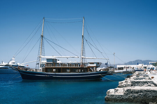 Traditional wooden schooner anchored in a clear blue Aegean Sea harbor