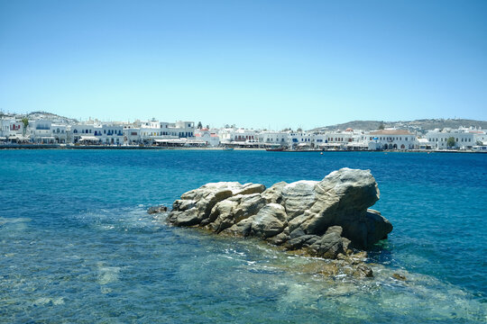 Iconic white buildings of Mykonos town line the sparkling blue Aegean Sea