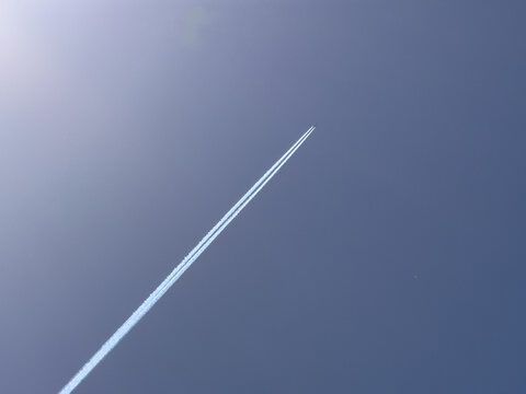 airplane in the sky with contrails