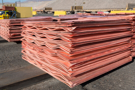 Stacks of refined copper cathodes with distinct wavy edges are prepared for dispatch at an open pit mining operation.