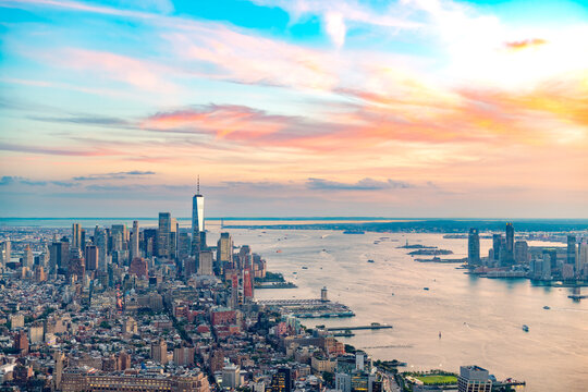 A high angle aerial panorama captures the densely packed financial district of downtown Manhattan, New York City, USA, with the expansive East River.