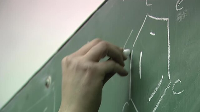 Close-Up of Teacher Writing on Chalkboard During Classroom Lesson