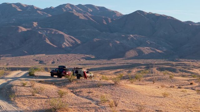 Experience aerial views of a teardrop camper and an SUV camping in Anza Borrego Desert State Park along Thimble Trail in California.
