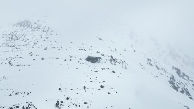 Drone pullback shot revealing snow-covered Phase 2 Gondola station in Gulmarg.