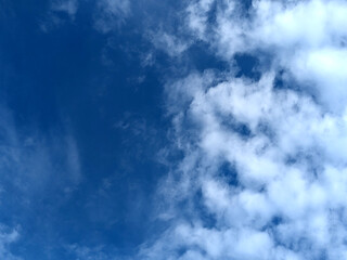 Fototapeta premium Moody white clouds across a blue black sky change in weather skyscape