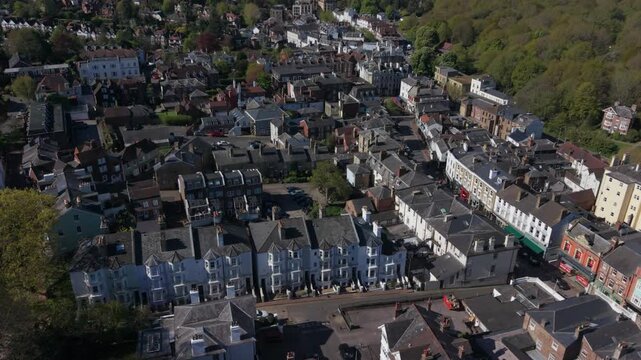Royal Tunbridge Wells towards historic Pantiles aerial view. Flying above houses and streets in old town on a sunny day in springtime. View of the High street with shops and restaurants.