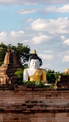 Obraz premium Ancient Buddha Statue Amidst Historic Brick Ruins in Ayutthaya Thailand.