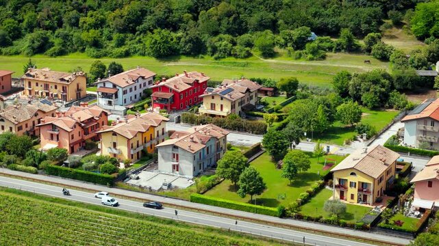 Cluster of residential houses in Costermano sul Garda with vineyard fields nearby, rural town landscape, aerial view