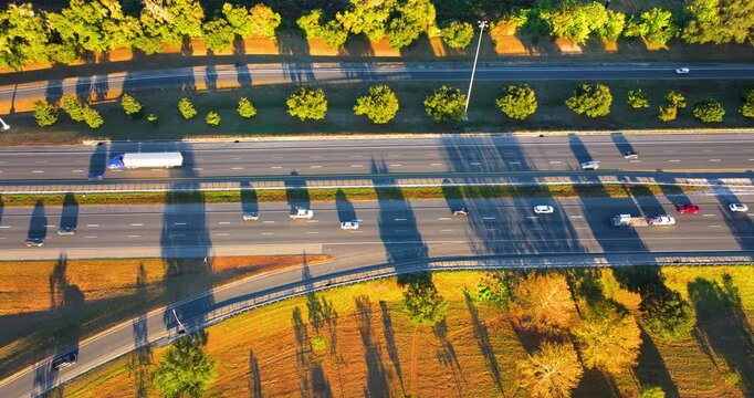 American interstate highway filled with moving vehicles and delivery trucks. Aerial top view of transportation artery showing car traffic flow and modern road engineering.