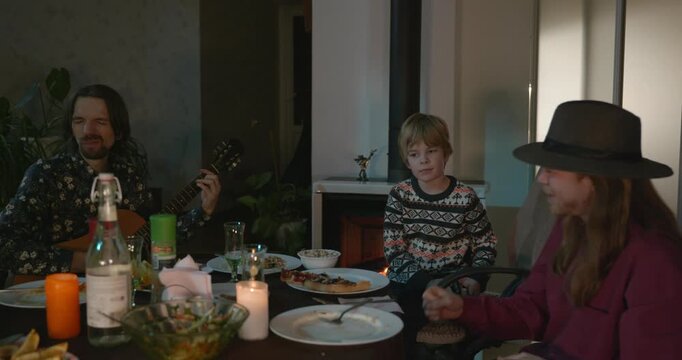 Men Friends and Kid Boy Play And Sing Music Together. Friends Have a Home Party Dinner. 4K 10-bit