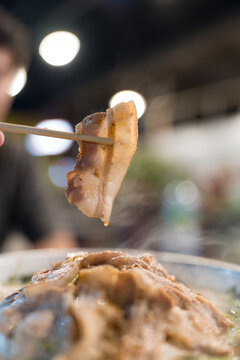 Use wood chopstick pick up bacon from the grill with smoke. Thai grilled buffet it called Moo ka ta