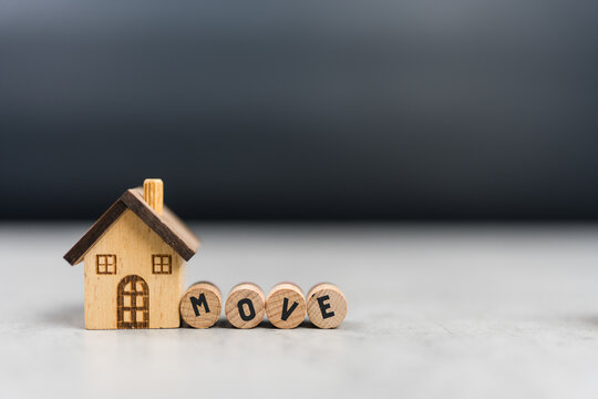 Wooden blocks with MOVE word and miniature house model. Mortgage for a home, Real estate concept.
