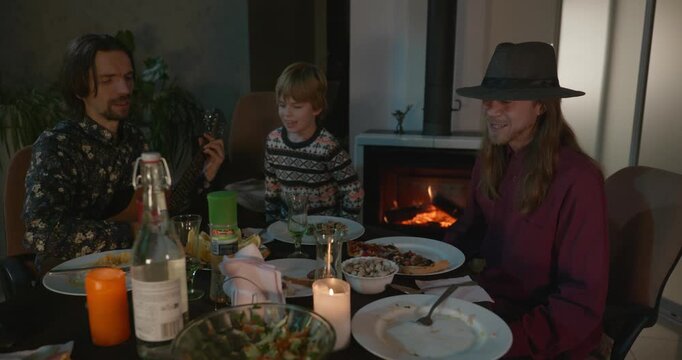 Men Friends and Kid Boy Play And Sing Music Together. Friends Have a Home Party Dinner. 4K 10-bit