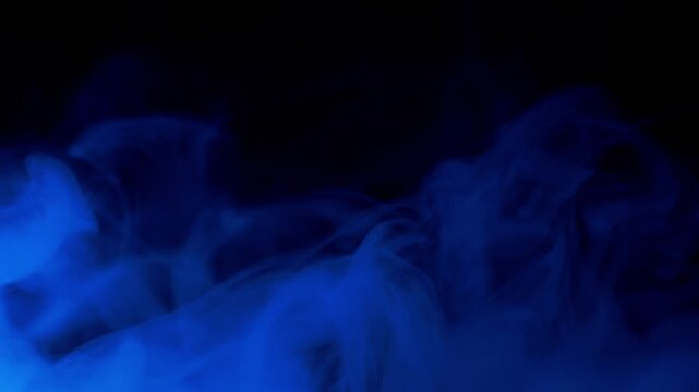 Plumes of smoke swirl and transition from blue to purple and red against a black background. Concept of mystery, creative energy, and abstract fluidity suitable for visual effects overlays.