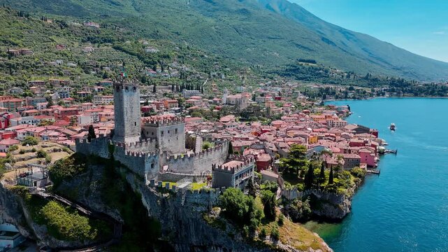 Scaliger Castle on cliff in Malcesine, Lake Garda. Scenic travel destination with historic fortress, lake and surrounding town
