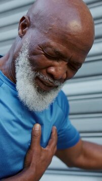 Fitness, chest pain and black man with heart attack, injury and angina outdoor in city. Breathing issue, exercise or mature person with health risk, workout fatigue or emergency with cardiac arrest