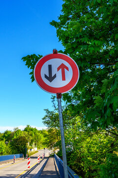 Traffic sign indicating priority for oncoming vehicles on a sunny day